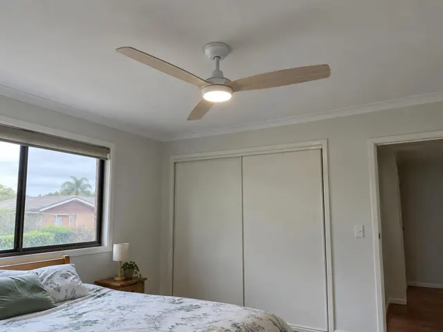 Ceiling fan fitted in a bedroom with white ceiling, grey walls, window and built-in robes in Bateau Bay