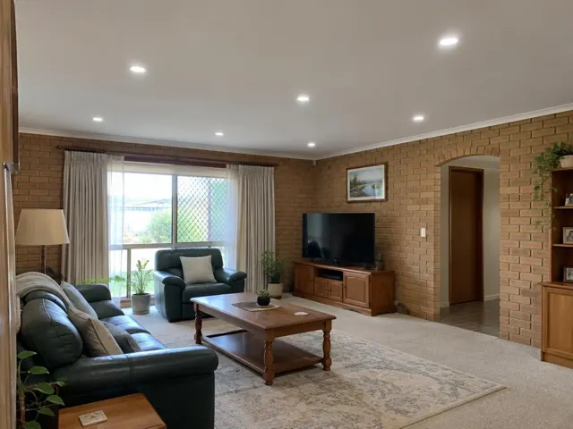 Living room with flush ceiling downlights in a brick home interior in Killarney Vale